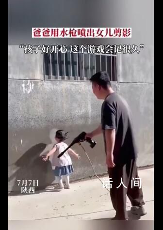 爸爸用水槍將女兒背影噴在墻上 女兒見到墻面上自己的剪影十分開心